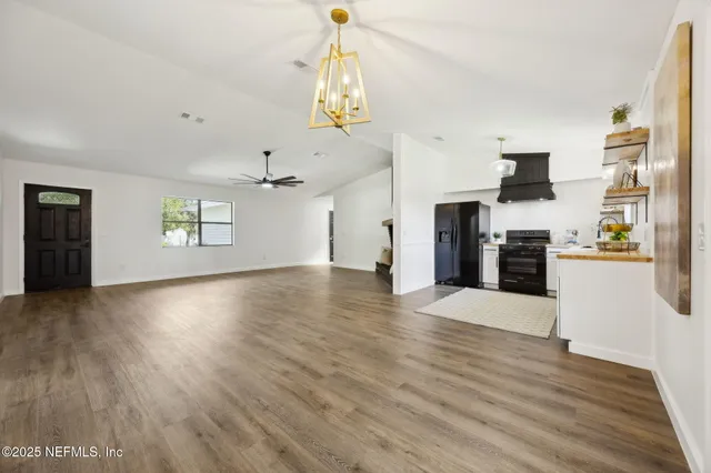 a large kitchen with a lot of counter space and wooden floor
