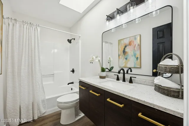 a view of an empty room with wooden floor and windows