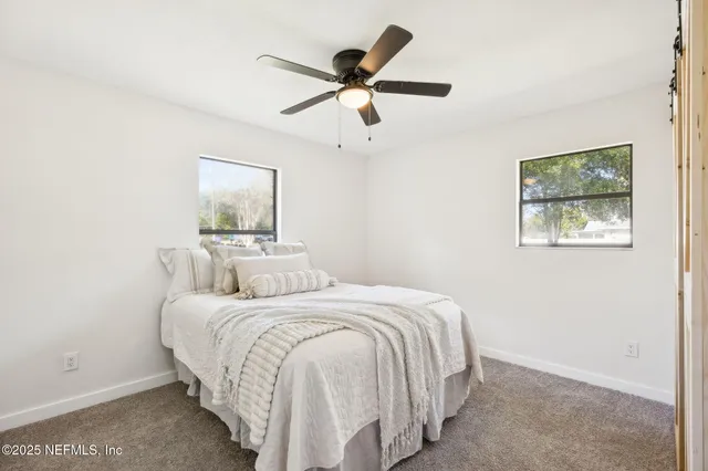 a backyard of a house with table and chairs under an umbrella