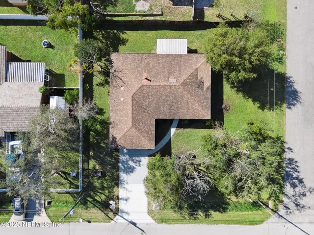 a view of a house with a yard and palm trees