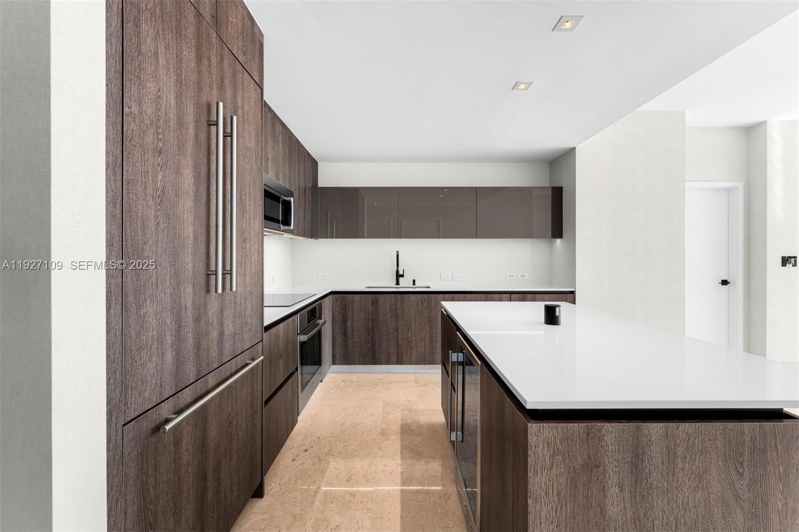 88 Southwest 7th Street, Unit 3907 Miami, FL 33130 - Photo 2 of 33 a kitchen with a sink a refrigerator and cabinets
