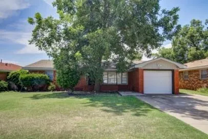 a front view of house with yard and trees