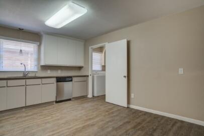 2611 49th Street Lubbock, TX 79413 - Photo 13 of 35 a kitchen with granite countertop white cabinets and white appliances