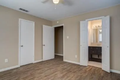 an empty room with wooden floor and closet