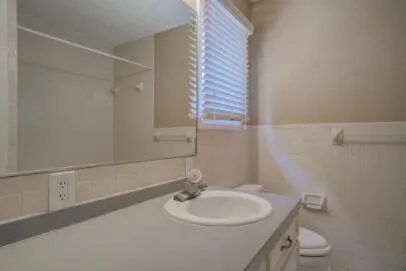 a bathroom with a toilet a sink and mirror