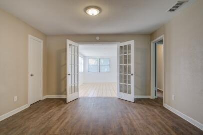 2611 49th Street Lubbock, TX 79413 - Photo 8 of 35 an empty room with wooden floor and windows