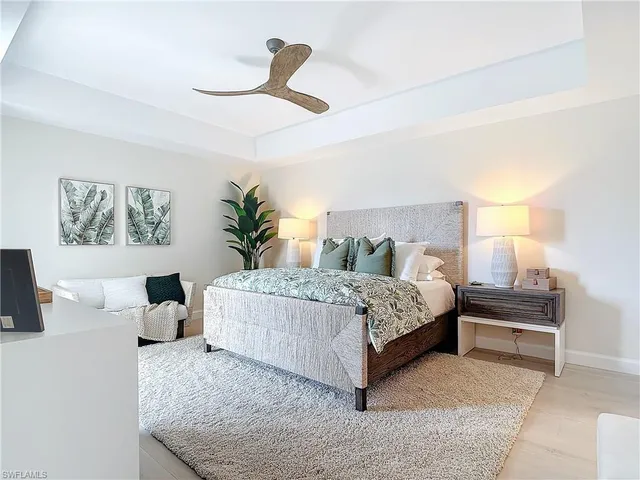 a bedroom with a large bed and ceiling fan