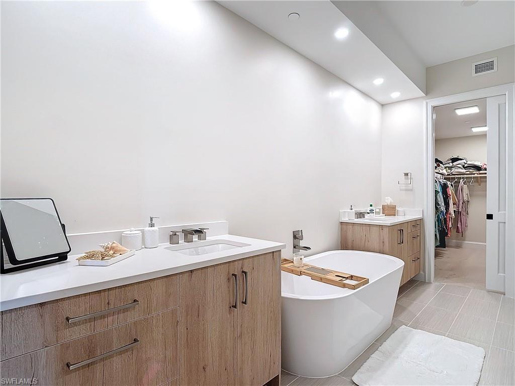 1125 Central Avenue, Unit 462 Naples, FL 34102 - Photo 20 of 48 a bathroom with a granite countertop sink and a mirror