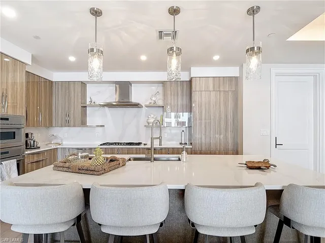 a kitchen with a dining table chairs sink and cabinets