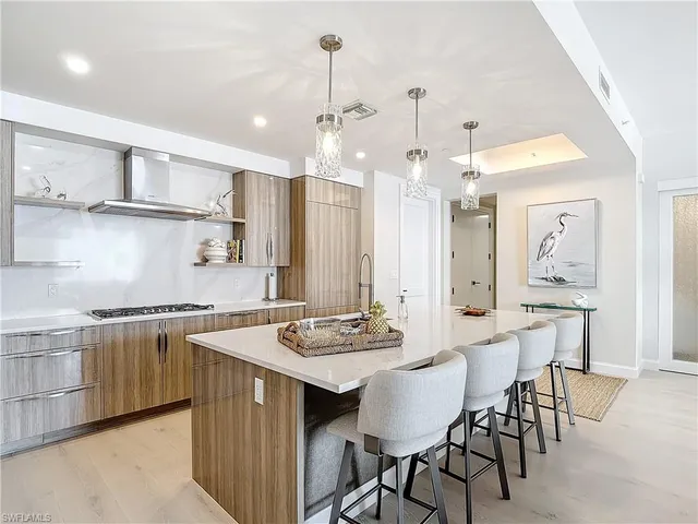 a kitchen with stainless steel appliances granite countertop a stove a sink a dining table and chairs