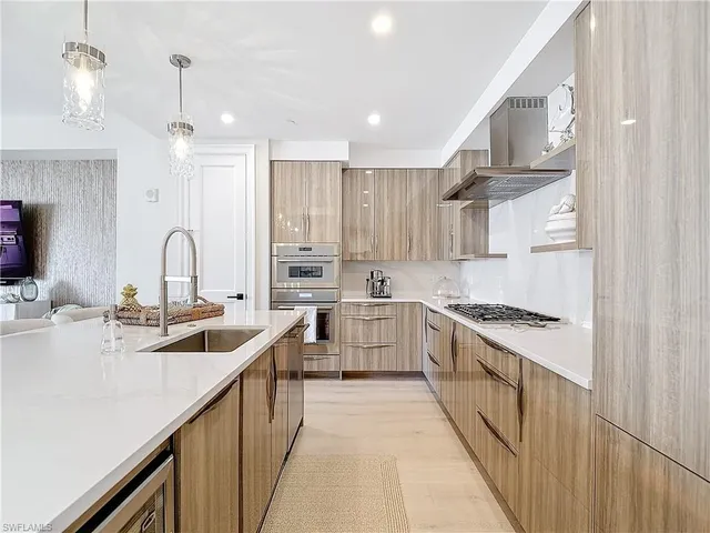 a kitchen with stainless steel appliances granite countertop a sink stove and cabinets