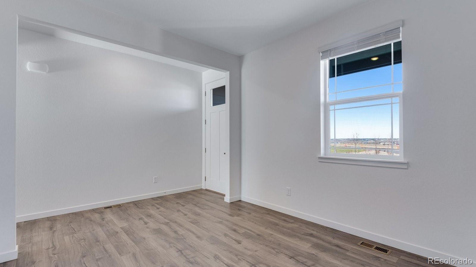 3434 Belleville Ridge Road Elizabeth, CO 80107 - Photo 12 of 48 a view of an empty room with wooden floor and a window