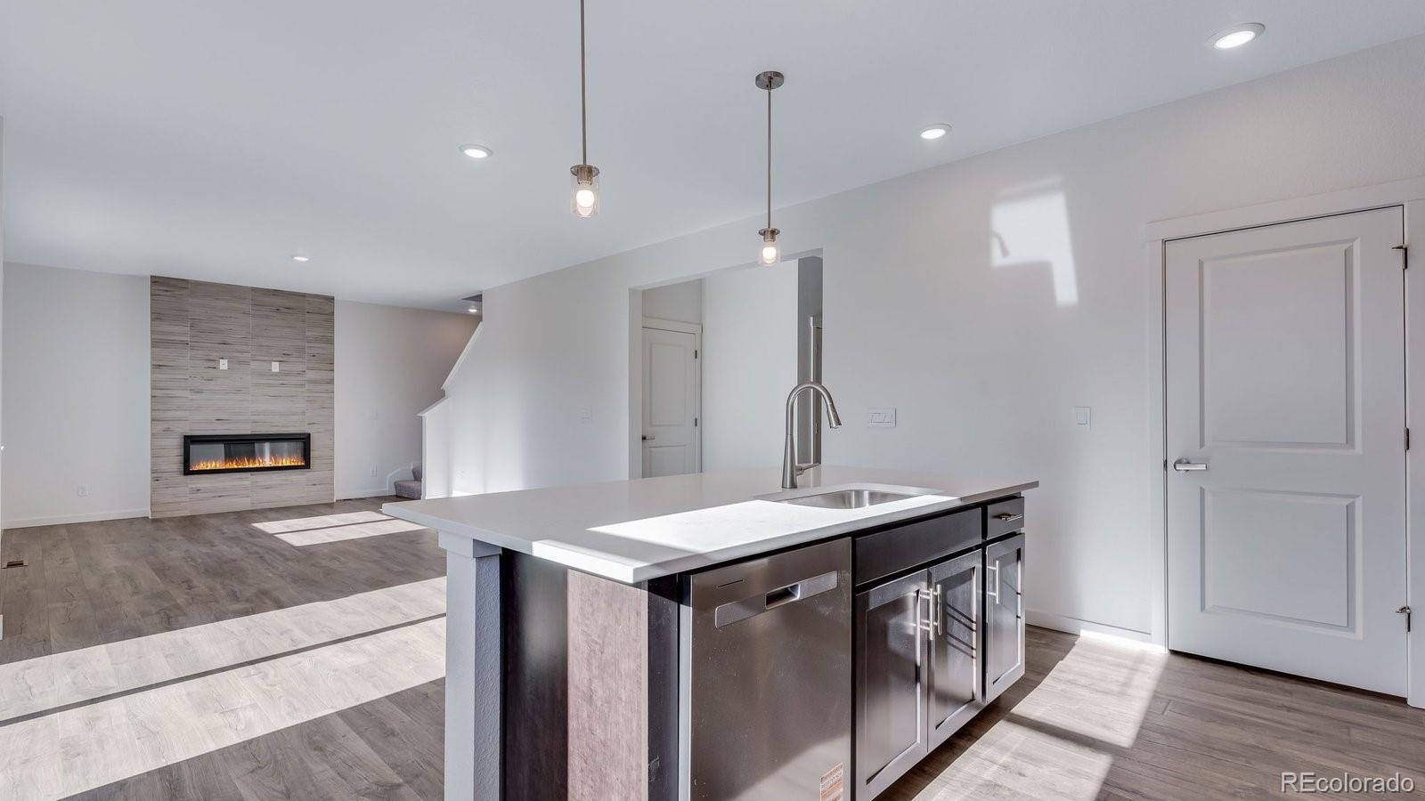 3434 Belleville Ridge Road Elizabeth, CO 80107 - Photo 16 of 48 a kitchen that has a sink a stove and a wooden floor