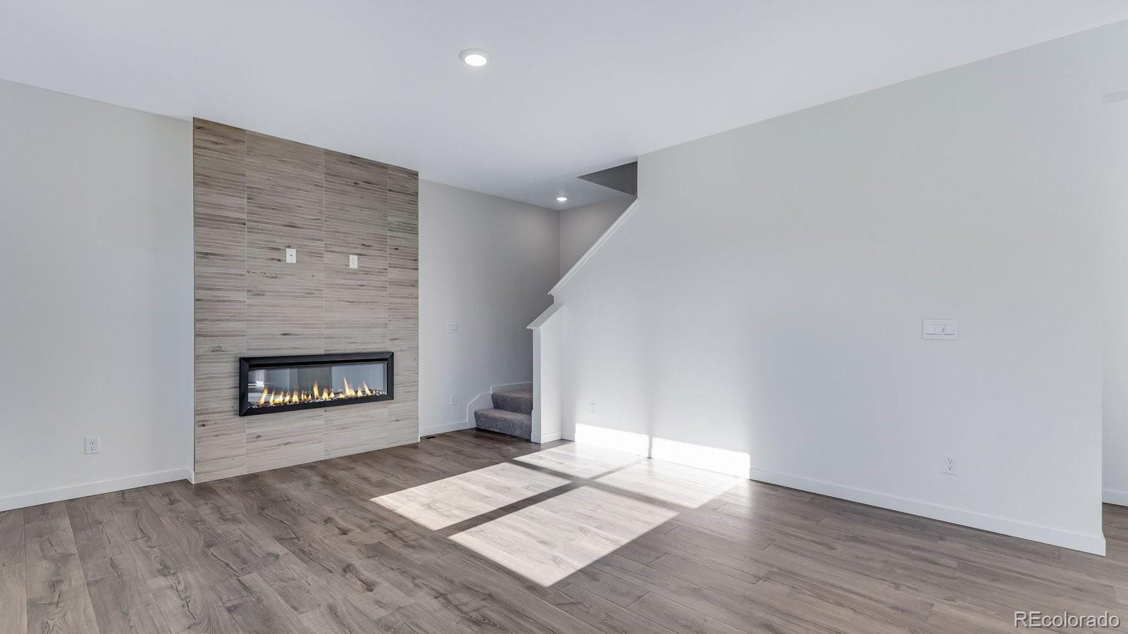 3434 Belleville Ridge Road Elizabeth, CO 80107 - Photo 27 of 48 an empty room with wooden floor a fireplace and windows