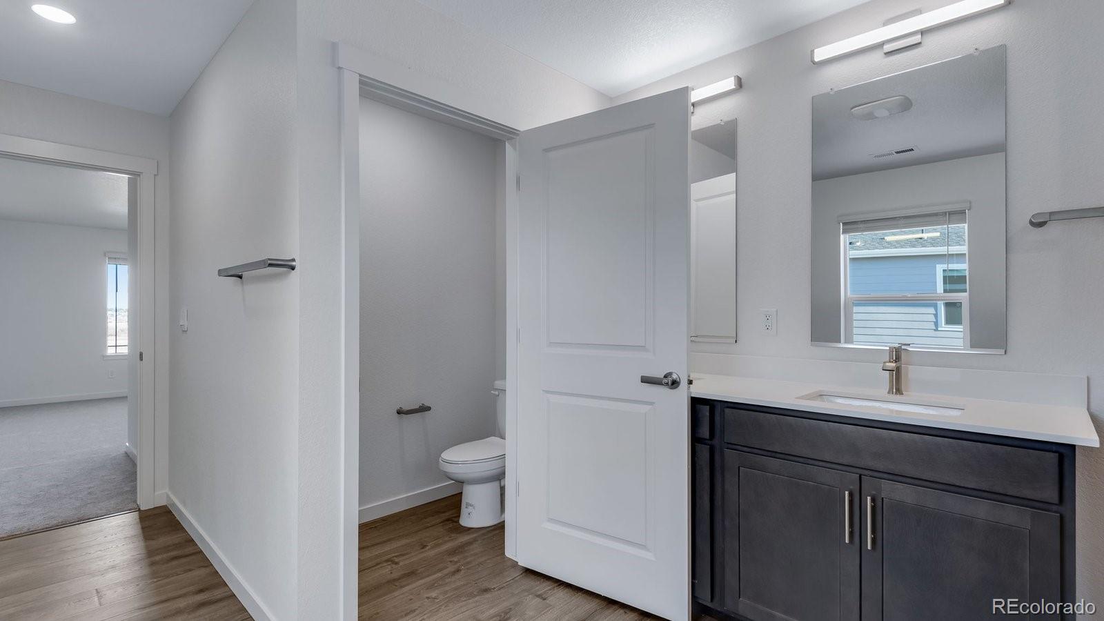 3434 Belleville Ridge Road Elizabeth, CO 80107 - Photo 45 of 48 a bathroom with a double vanity sink toilet and mirror