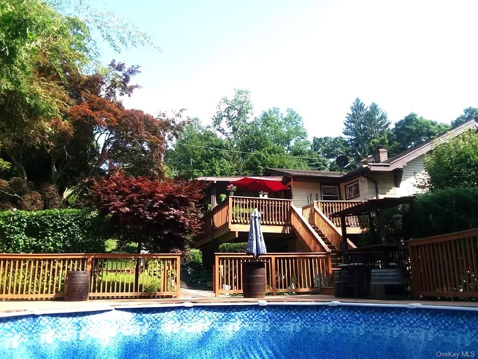 a view of house with swimming pool and sitting area