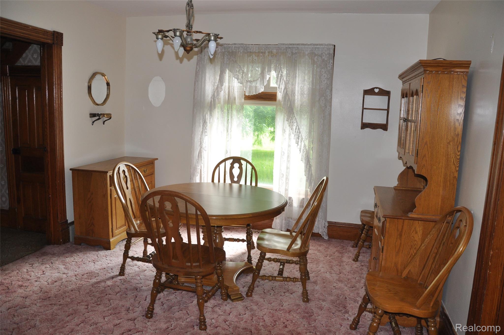 3954 Mayville Road Silverwood, MI 48760 - Photo 15 of 30 Dining area featuring a central chandelier, a window with natural light, and a built-in wooden hutch