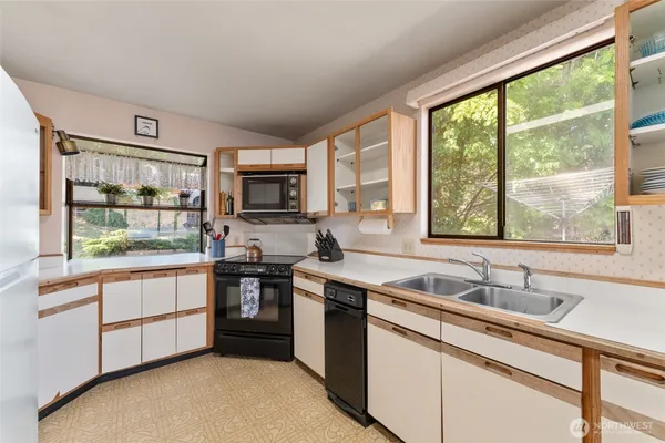 a kitchen with stainless steel appliances granite countertop a stove a sink and a microwave