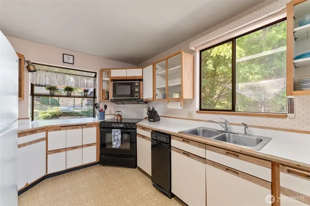 a kitchen with stainless steel appliances granite countertop a stove a sink and a microwave