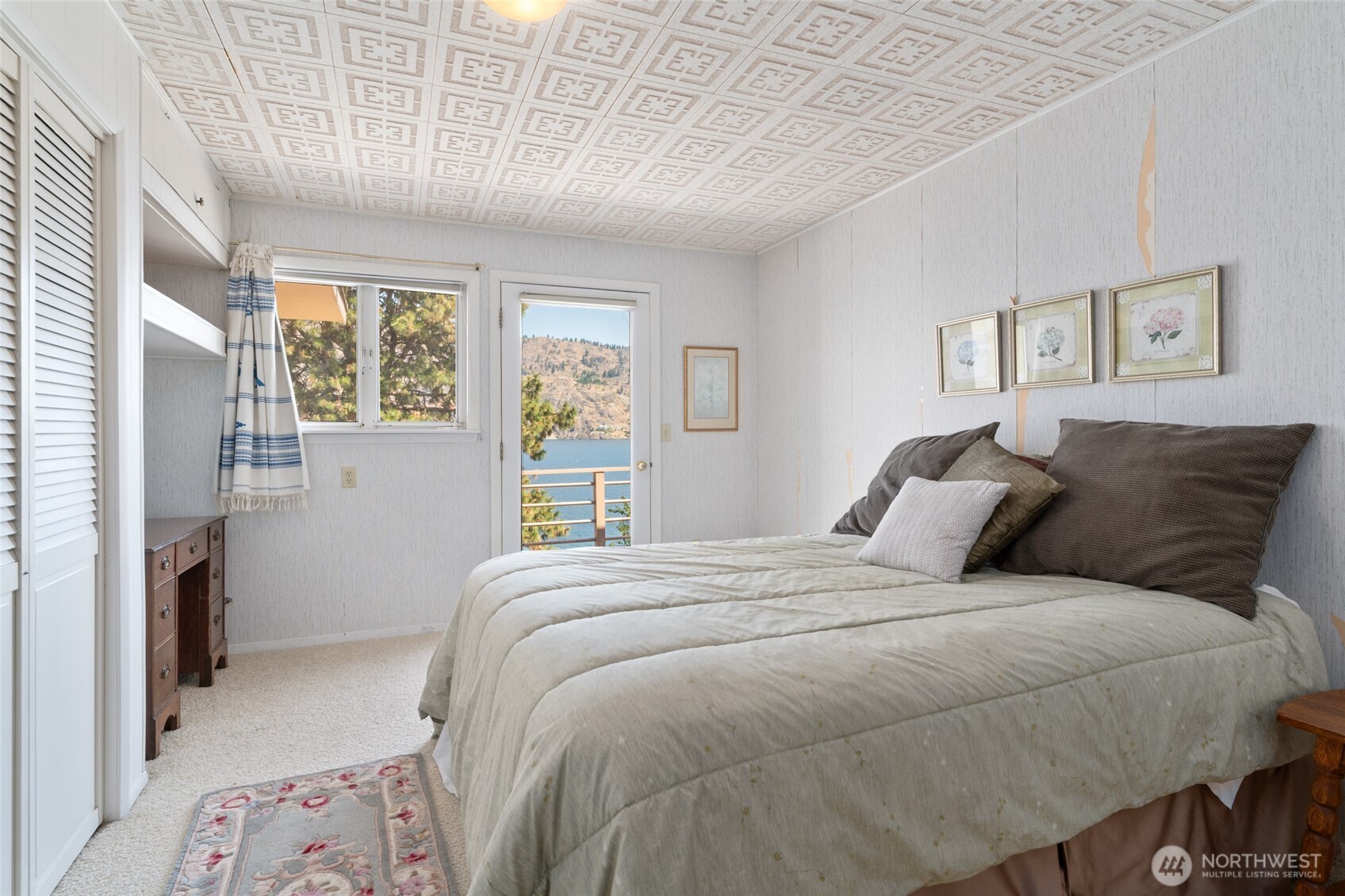 15082 South Lakeshore Road Chelan, WA 98816 - Photo 15 of 36 a bedroom with a large bed and a window