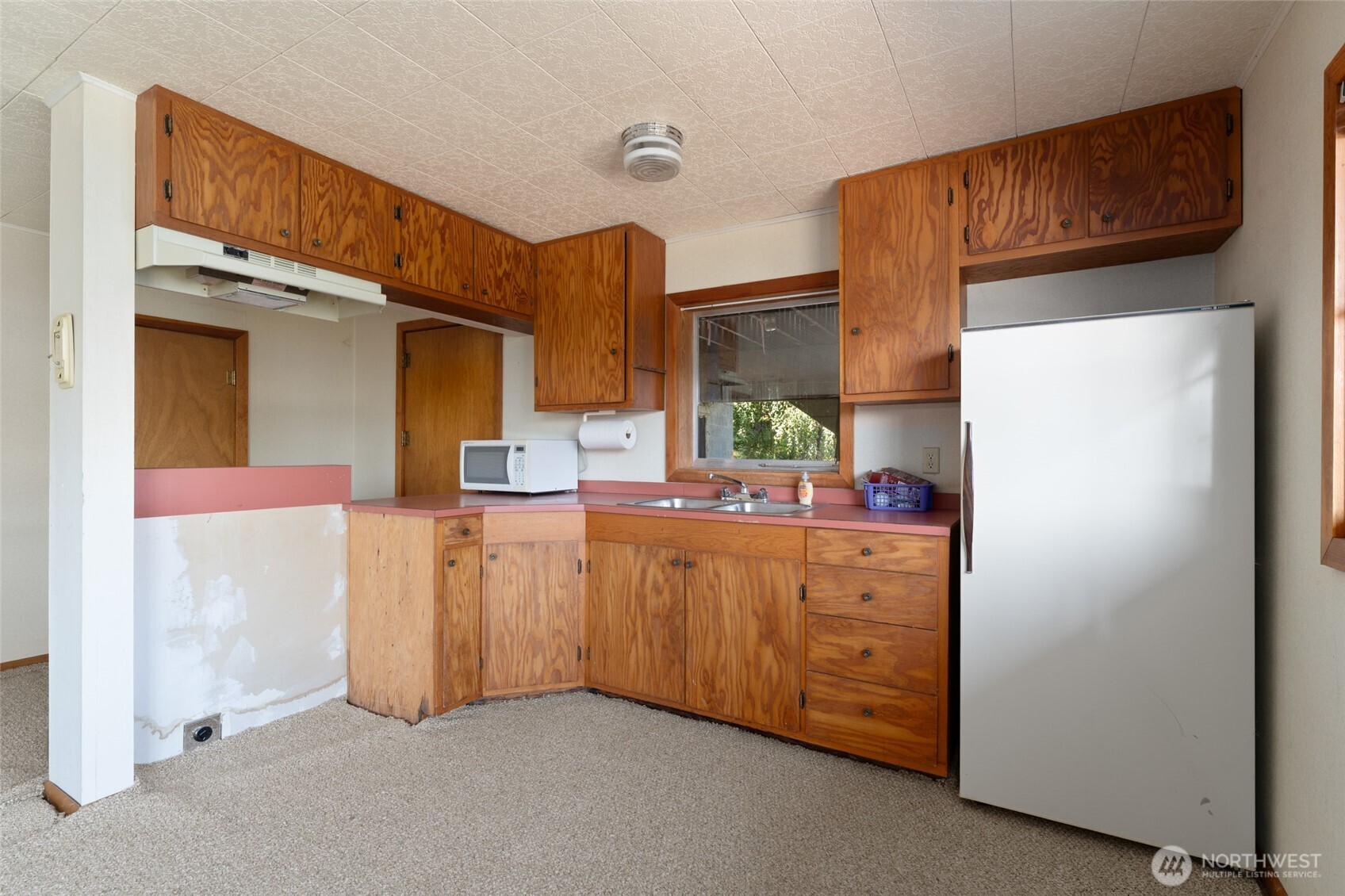 15082 South Lakeshore Road Chelan, WA 98816 - Photo 25 of 36 a kitchen with cabinets a sink and a refrigerator