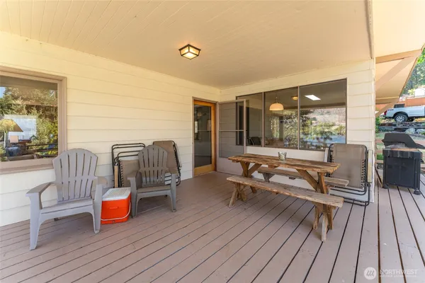 a living room with patio furniture and wooden floor