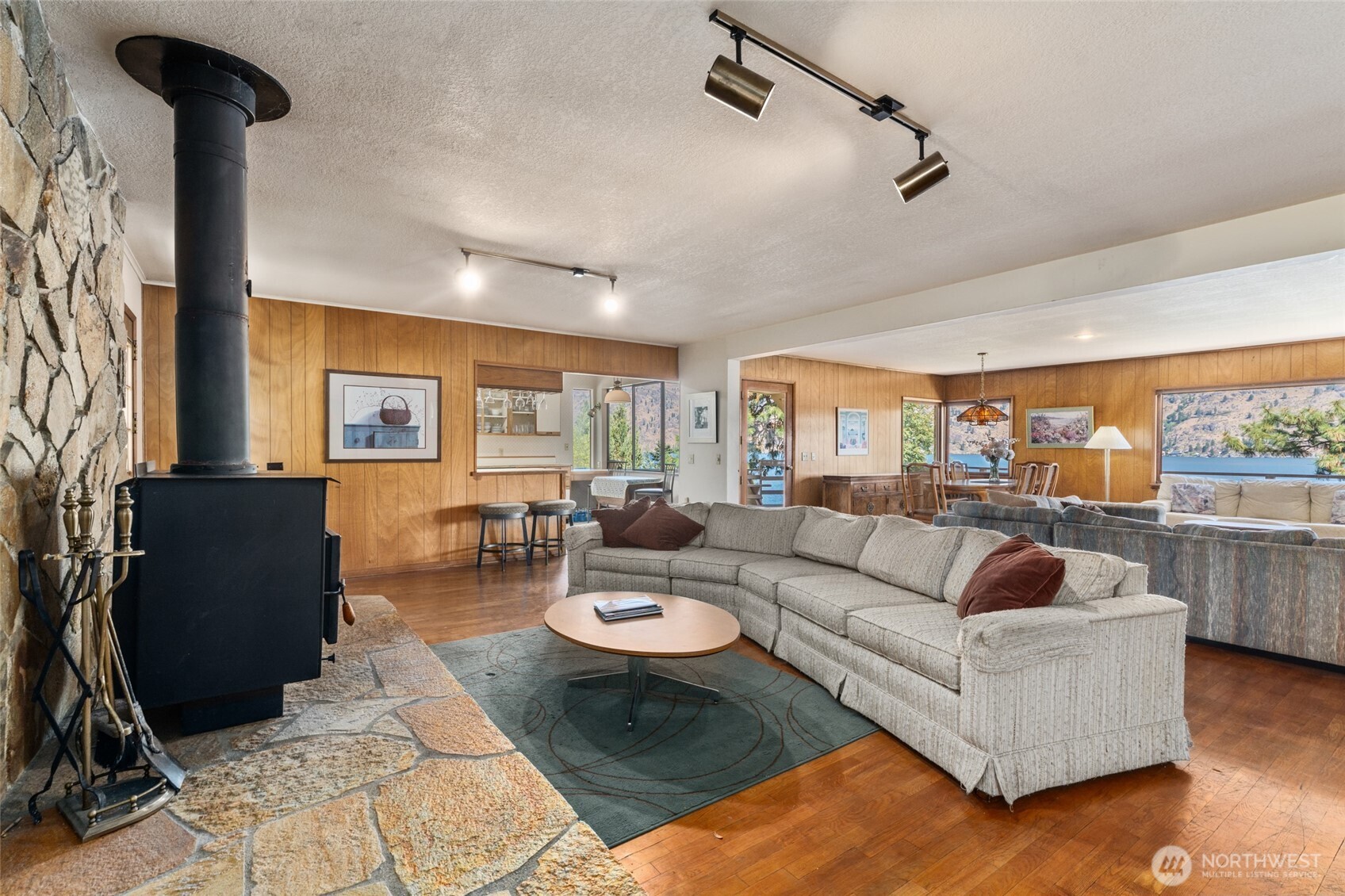 15082 South Lakeshore Road Chelan, WA 98816 - Photo 6 of 36 a living room with furniture a rug and a chandelier