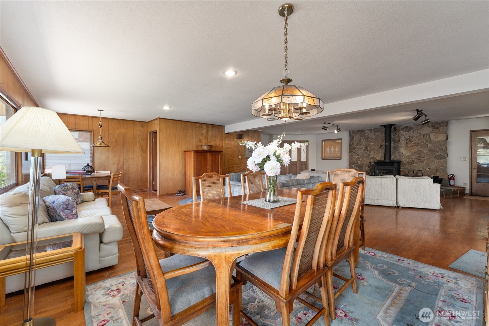 15082 South Lakeshore Road Chelan, WA 98816 - Photo 10 of 36 a dining room with wooden floor a chandelier a wooden table and chairs