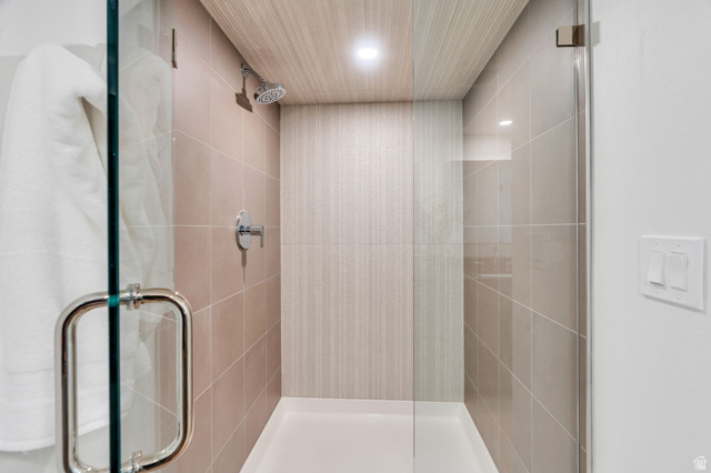 3813 North Foothill Drive Provo, UT 84604 - Photo 30 of 71 Glass-enclosed shower with ceramic tile walls, a wood-finish ceiling, and a bright overhead light