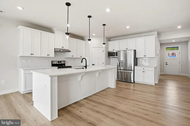 a kitchen with white cabinets and stainless steel appliances