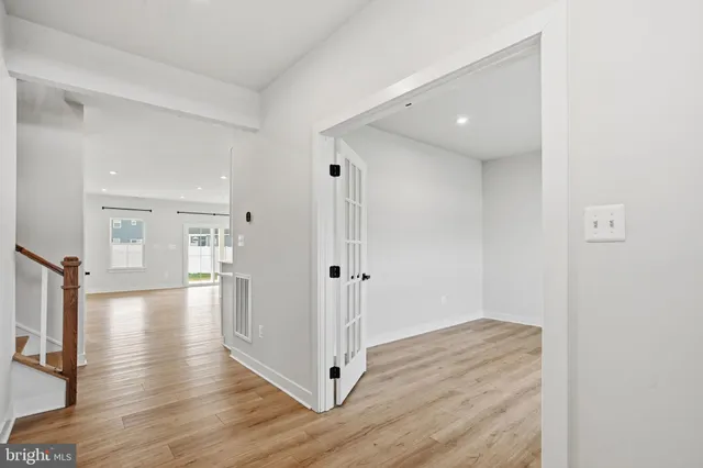 a view of a hallway with wooden floor and closet area