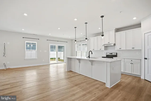 a large white kitchen with lots of counter space sink and appliances