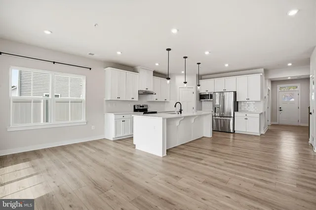 a large kitchen with stainless steel appliances refrigerator sink and cabinets