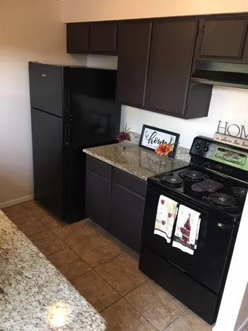 a kitchen with stainless steel appliances granite countertop a refrigerator and a stove