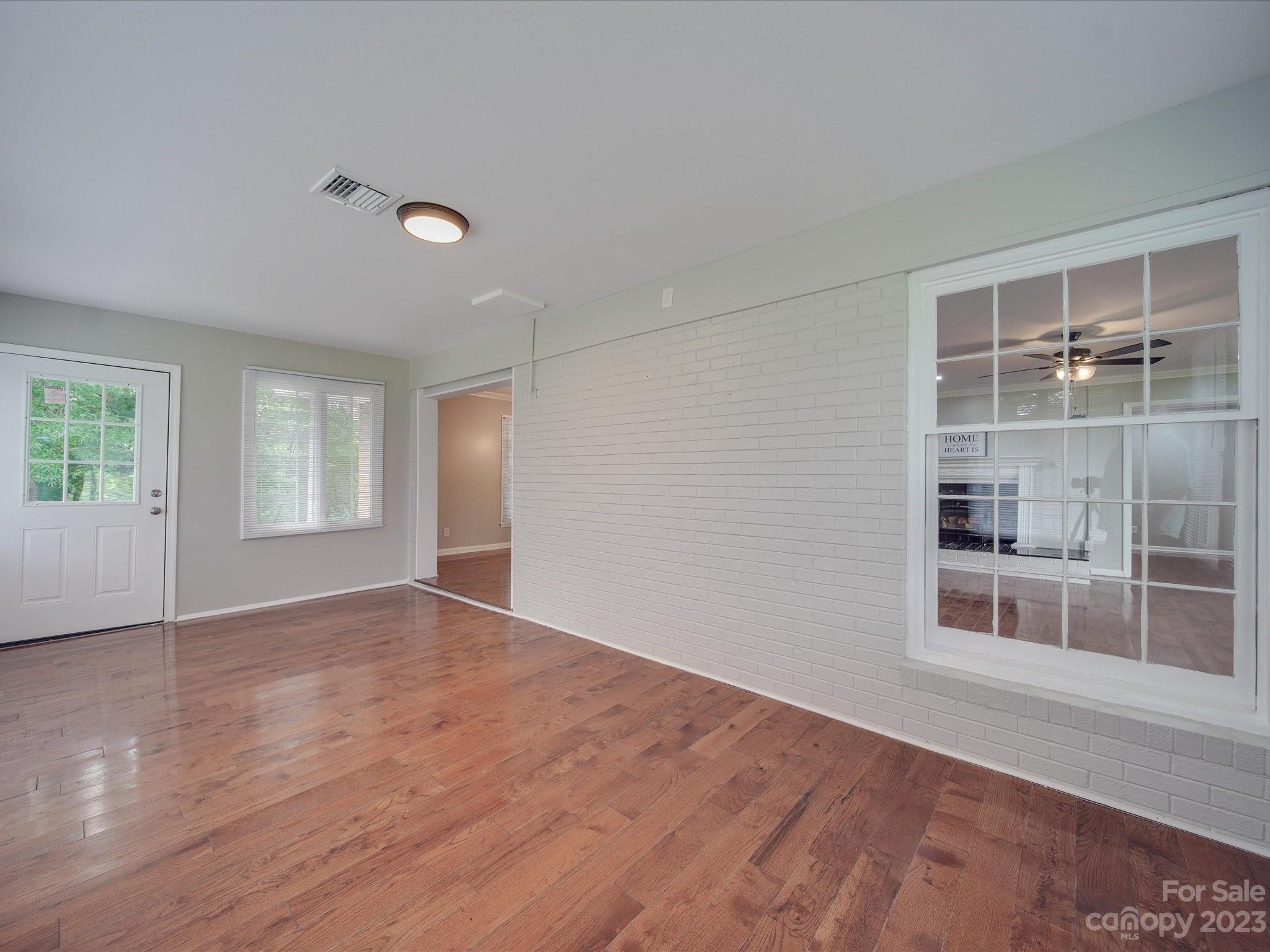1035 Blake Road Albemarle, NC 28001 - Photo 12 of 45 an empty room with wooden floor and windows