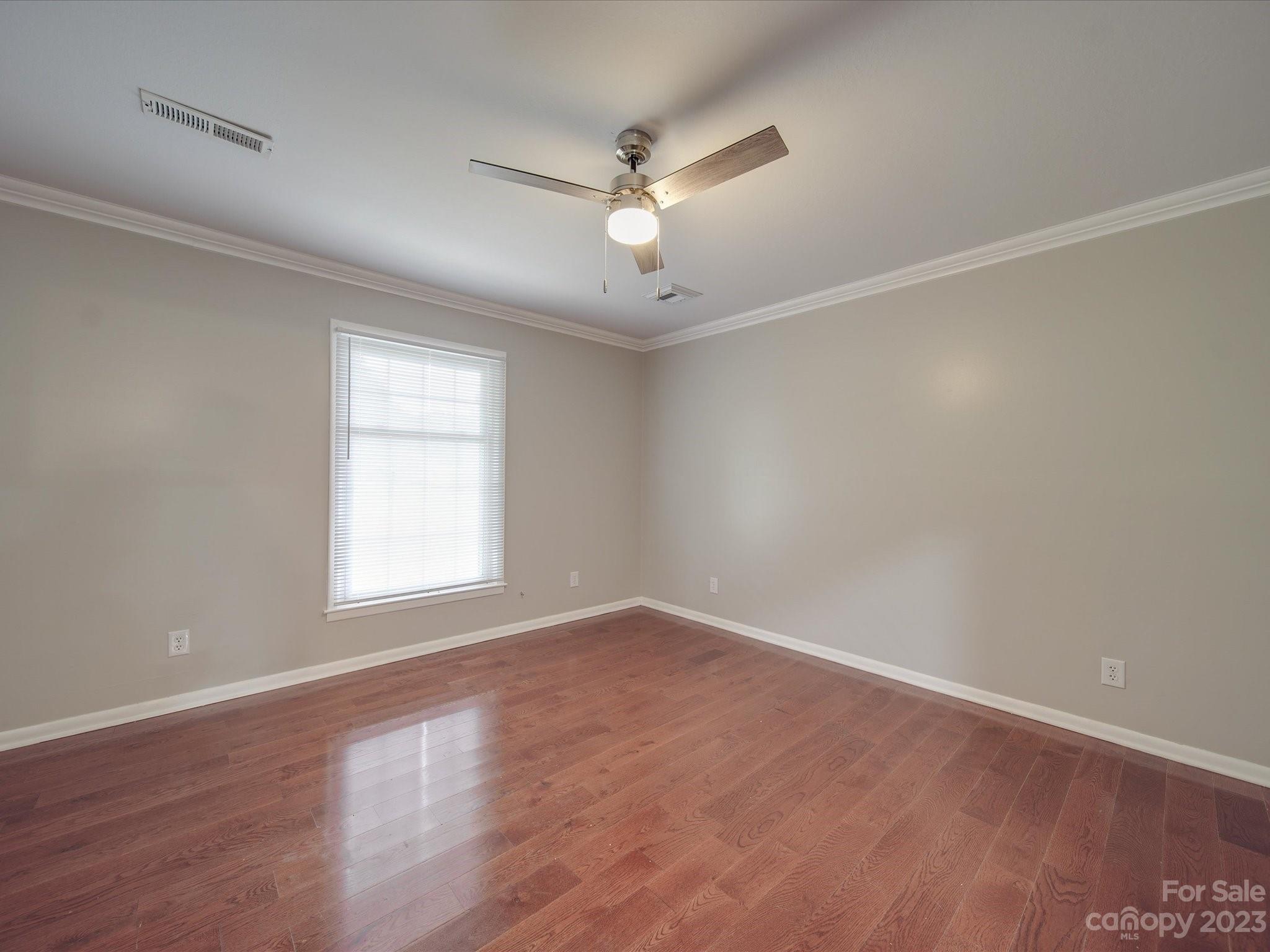 1035 Blake Road Albemarle, NC 28001 - Photo 21 of 45 an empty room with wooden floor ceiling fan and windows