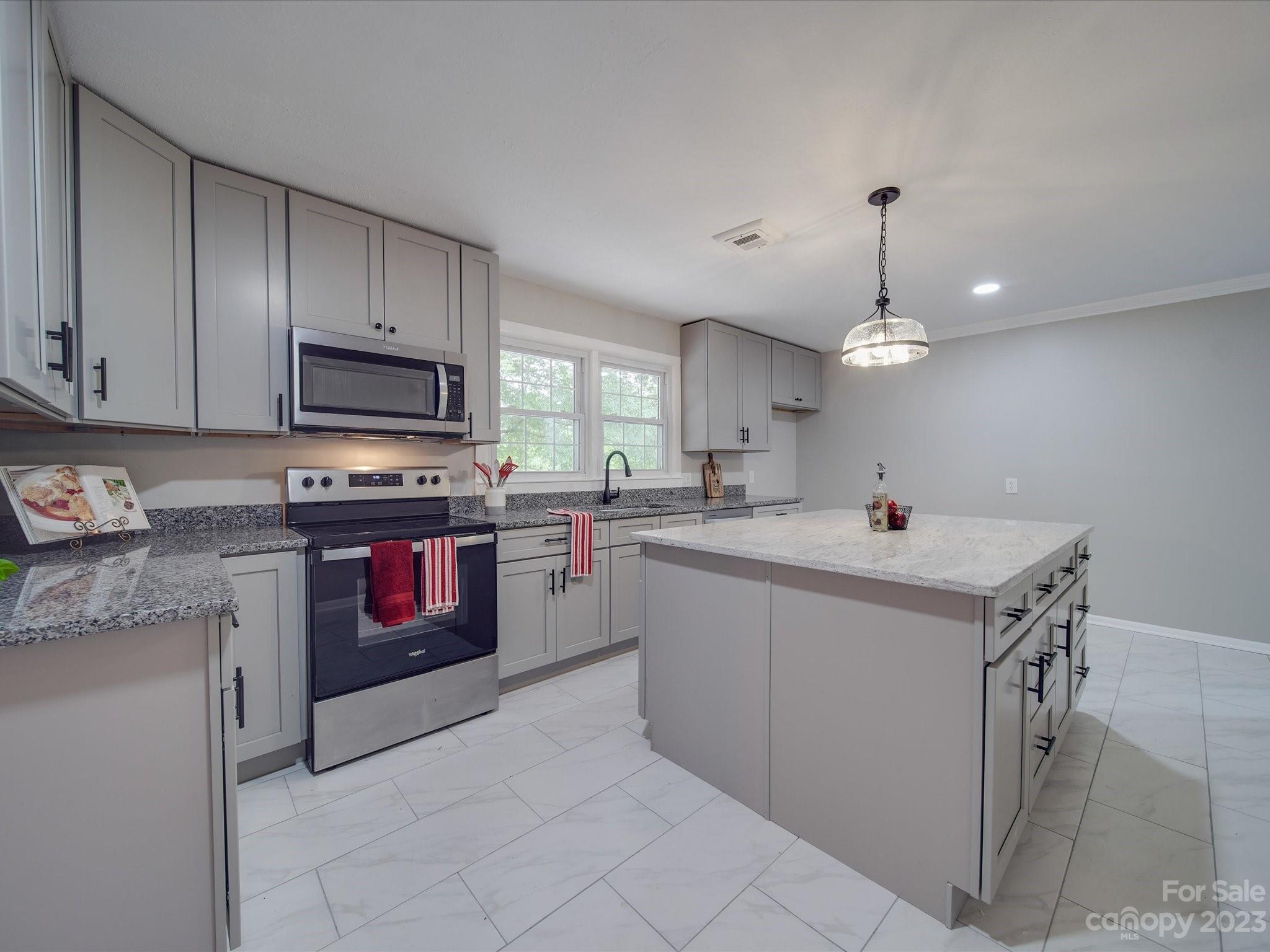 1035 Blake Road Albemarle, NC 28001 - Photo 8 of 45 a kitchen with stainless steel appliances kitchen island a white cabinets and wooden floor