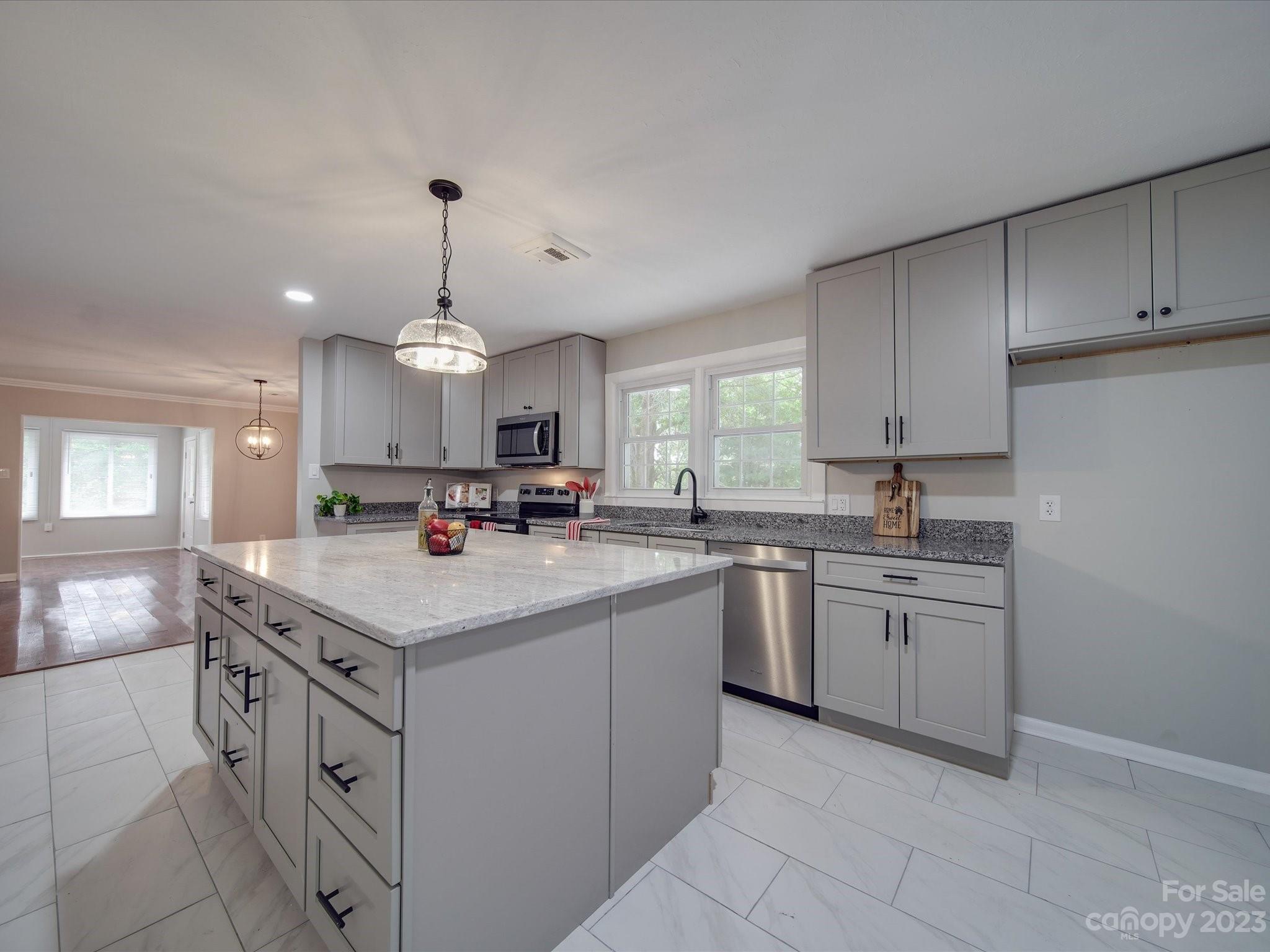 1035 Blake Road Albemarle, NC 28001 - Photo 9 of 45 a kitchen with kitchen island granite countertop a sink a stove and cabinets