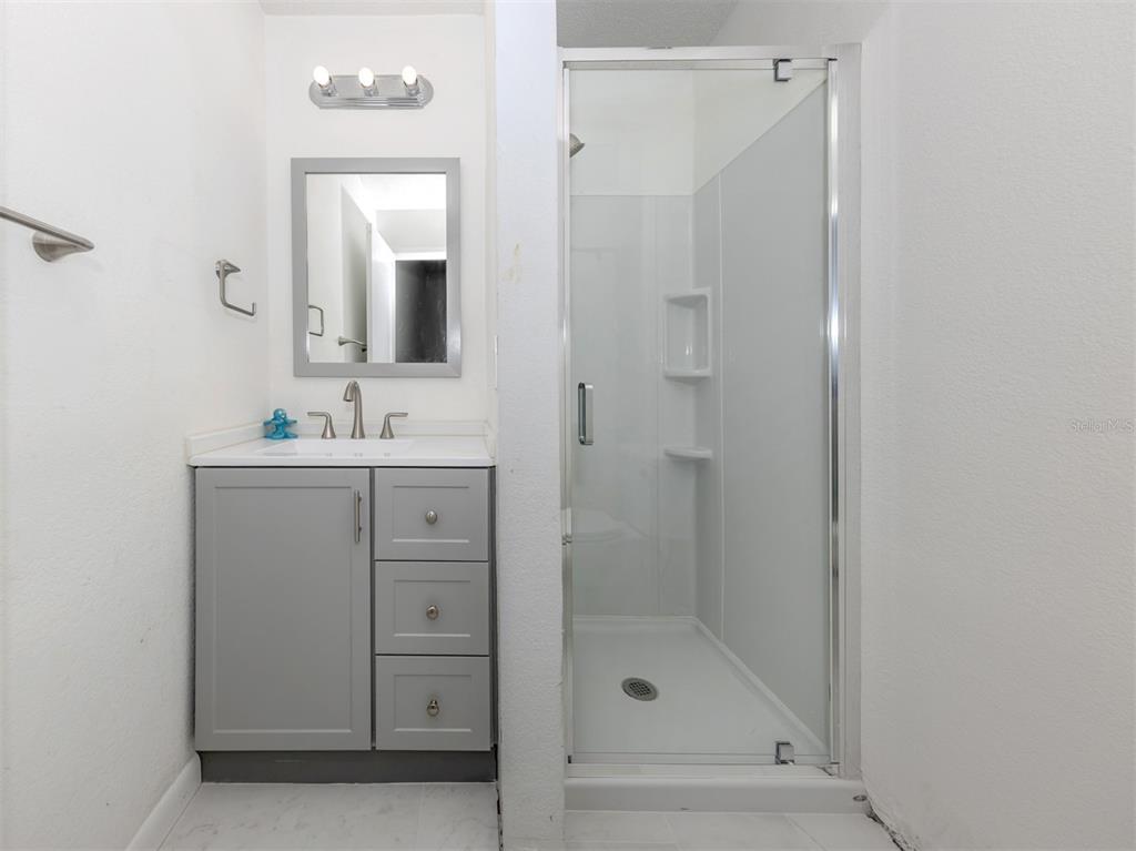 1555 Tarpon Center Drive, Unit 132 Venice, FL 34285 - Photo 26 of 58 a bathroom with a shower sink and mirror