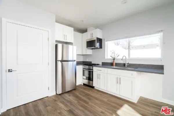 a kitchen with stainless steel appliances granite countertop a refrigerator sink and microwave