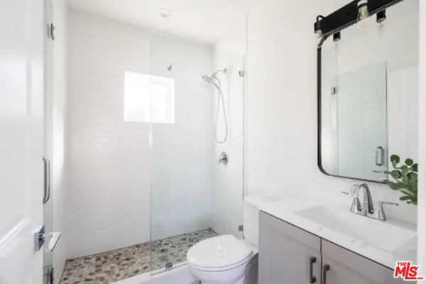 a bathroom with a sink a toilet and shower