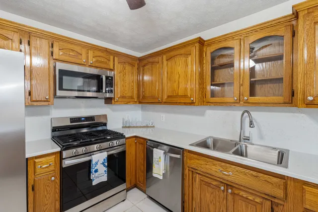 a kitchen with stainless steel appliances granite countertop a stove microwave and sink