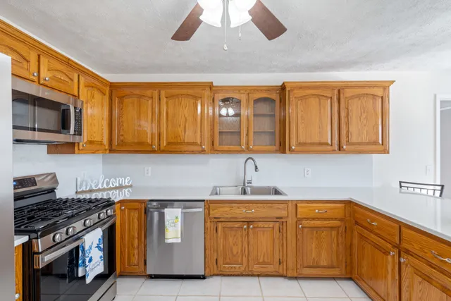 a kitchen with stainless steel appliances granite countertop a sink a stove and cabinets