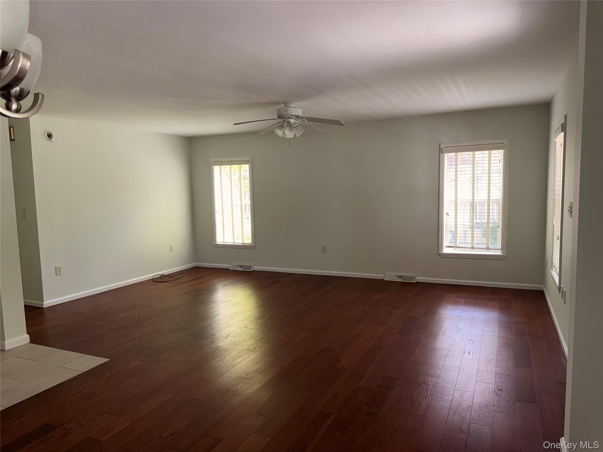 1661 Old Country Road, Unit 516 Riverhead, NY 11901 - Photo 10 of 50 an empty room with wooden floor and windows