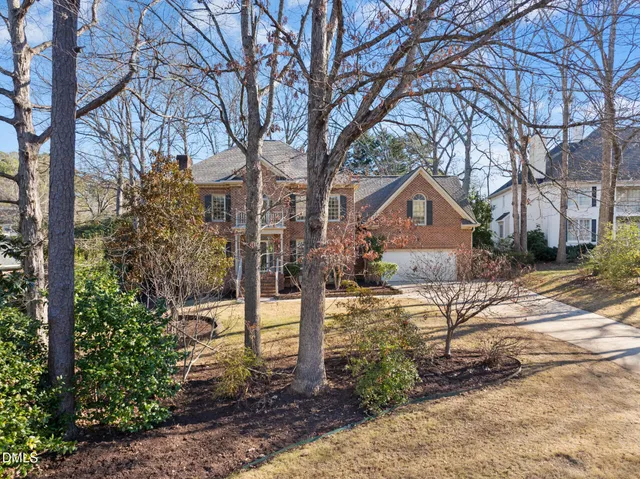 a front view of a house with yard and trees