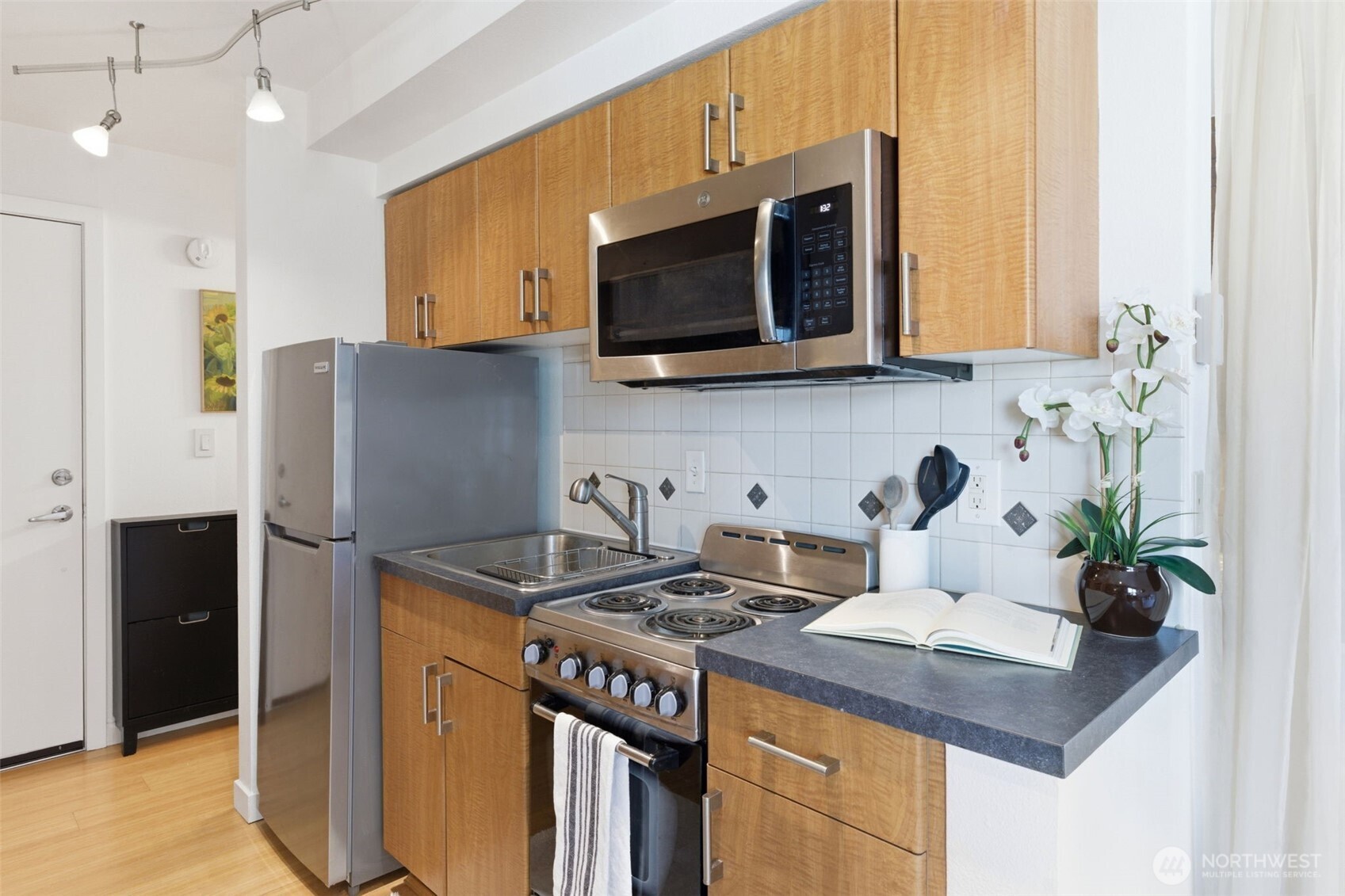 905 Cherry Street, Unit 306 Seattle, WA 98104 - Photo 4 of 25 a kitchen with stainless steel appliances granite countertop a sink and a refrigerator