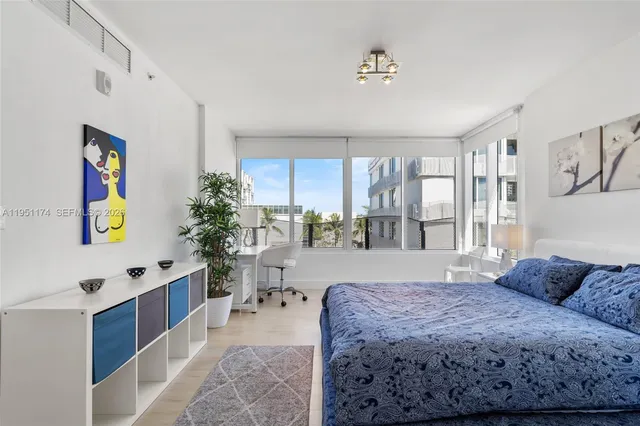 a spacious bedroom with a bed window and table