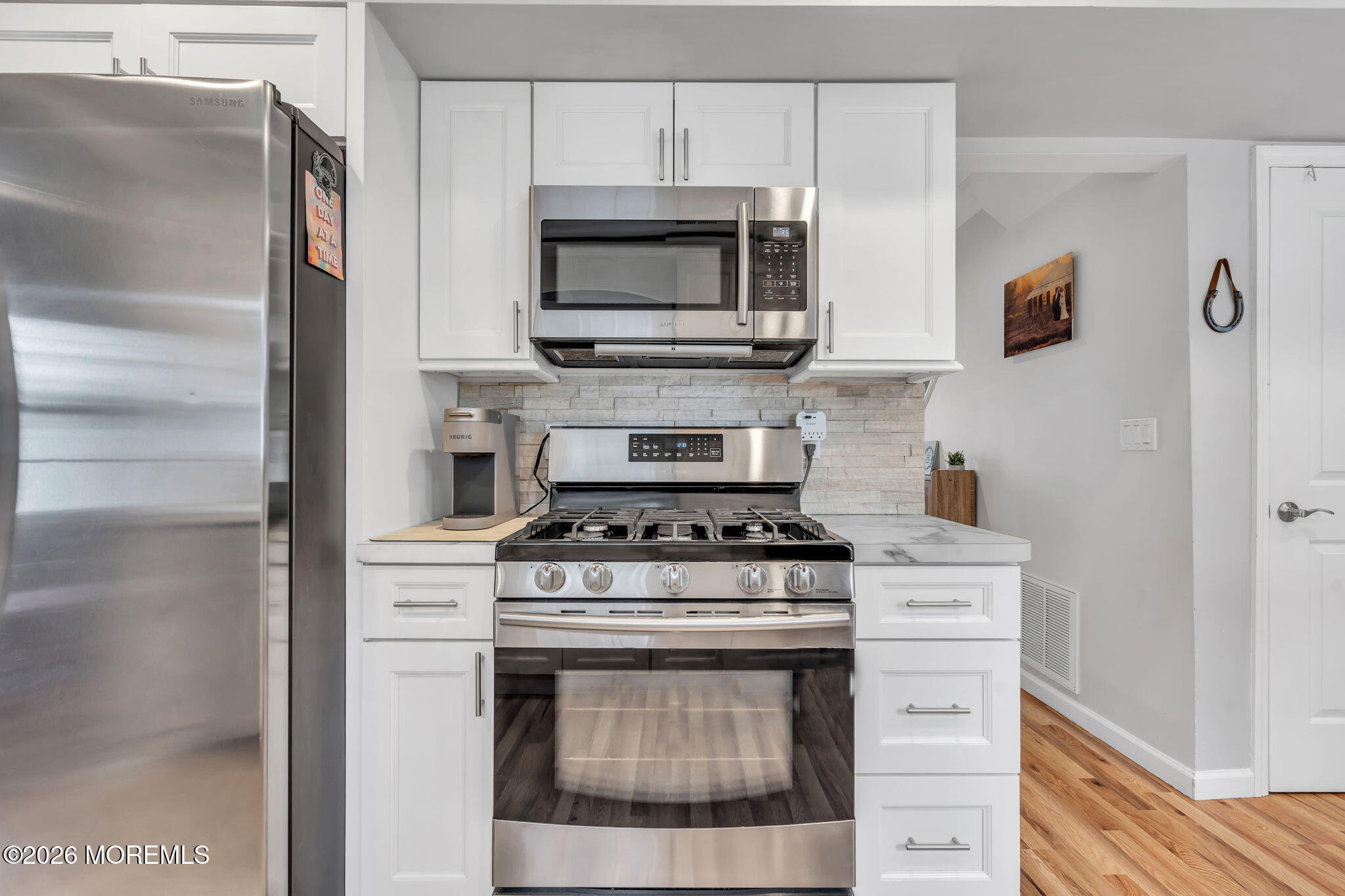 24 Eric Drive Howell, NJ 07731 - Photo 21 of 58 a kitchen with stainless steel appliances a stove a microwave and cabinets