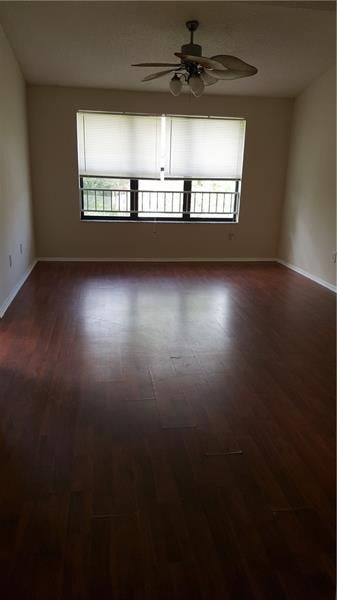 4541 West McNab Road, Unit 26 Pompano Beach, FL 33069 - Photo 12 of 12 a view of an empty room with wooden floor and a window