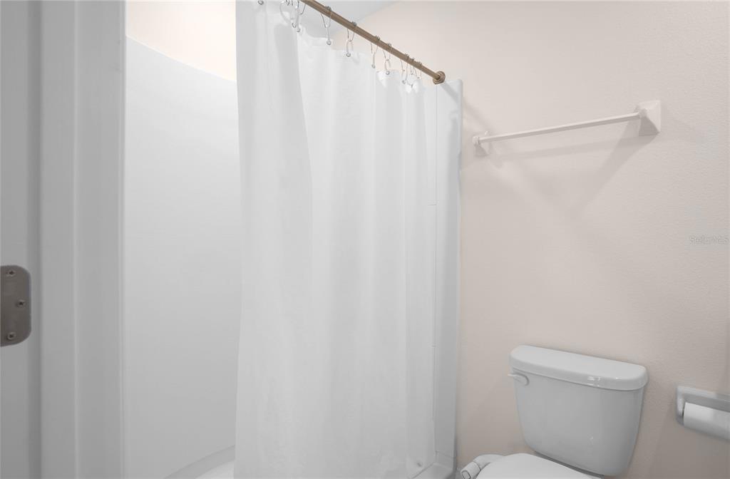 8471 Clearway Drive Wildwood, FL 34785 - Photo 16 of 32 a bathroom with a shower curtain and a toilet